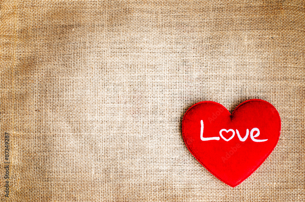 Red heart with love text on gunny sackcloth texture background Red heart with love text on gunny sackcloth texture background