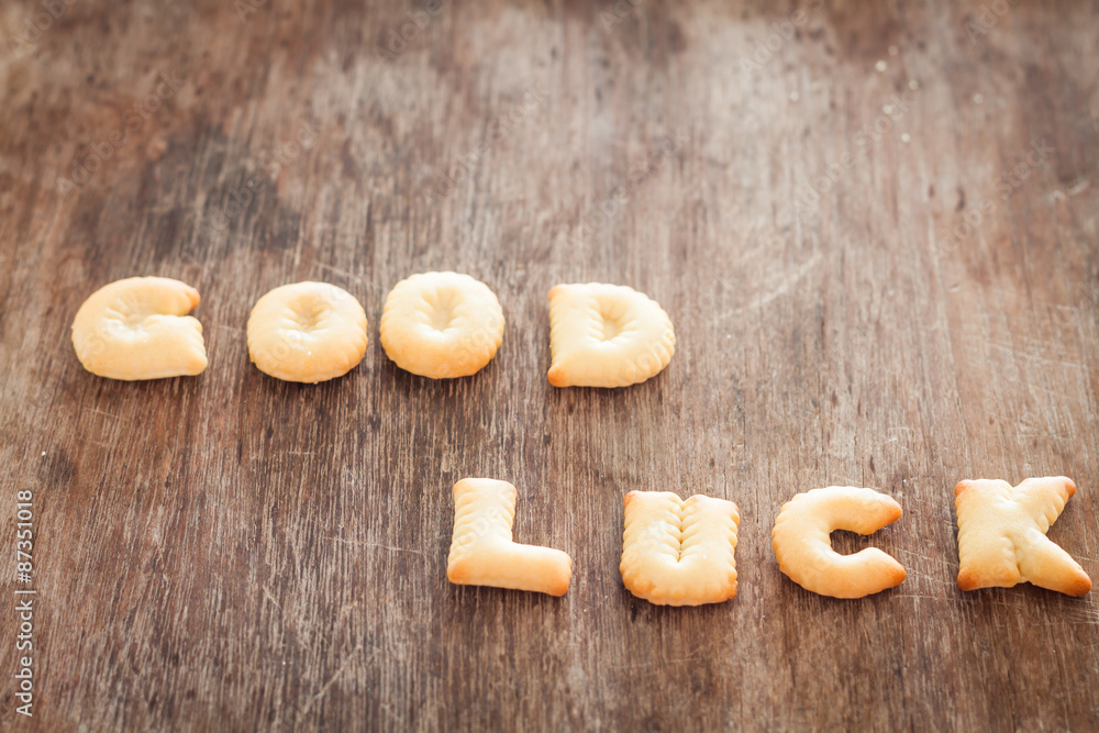 Good luck alphabet biscuit on wooden table