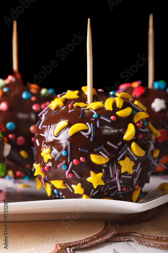 Delicious apples in chocolate with candy sprinkles vertical
