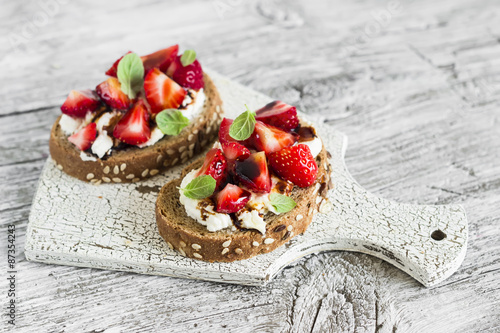 Tableau sur toile sandwich with strawberries, soft cheese and balsamic vinegar on a light wooden b