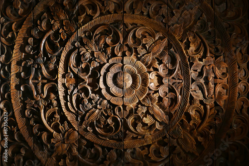 Pattern of flower carved on wood background.