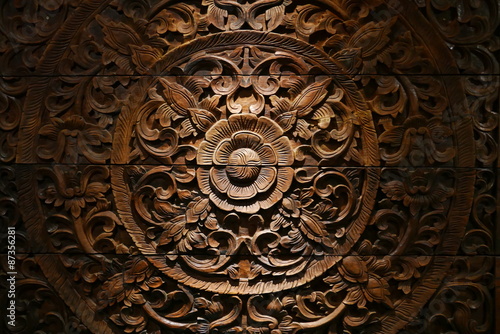 Pattern of flower carved on wood background.