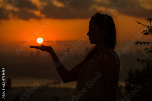 Single adult woman silhouette at sunset