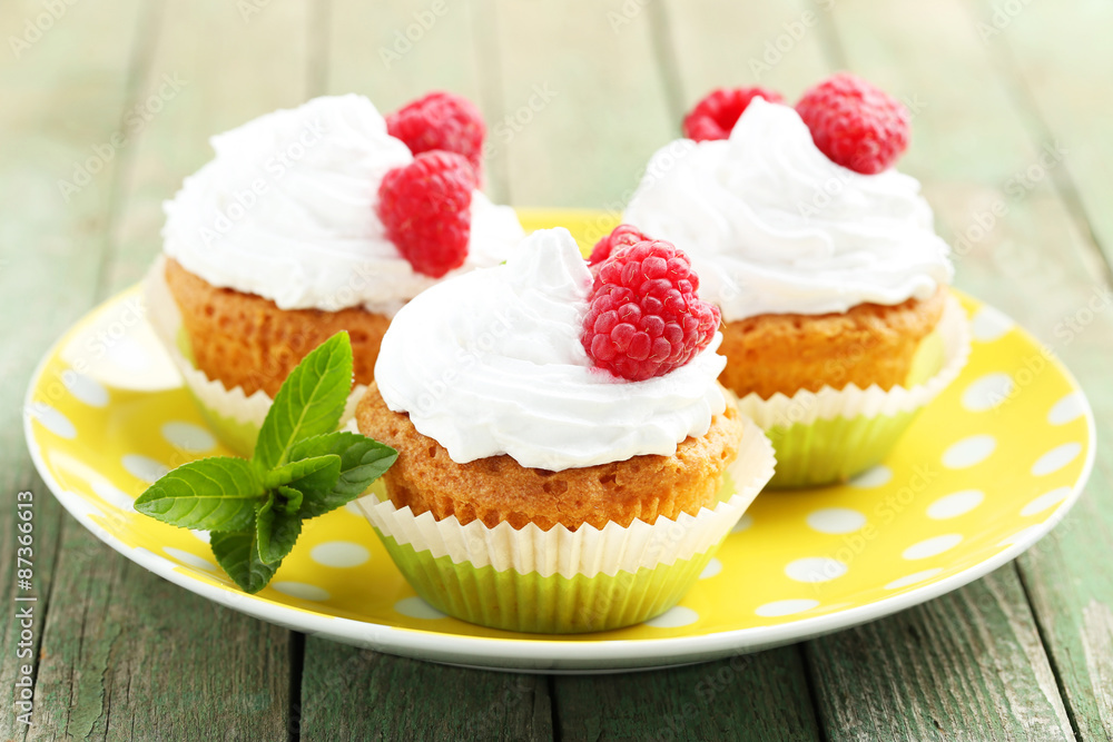 Raspberry cupcakes on green wooden background Raspberry cupcakes on green wooden background