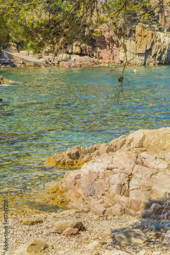 Turquoise water on rocks coast on a Mediterranean beach