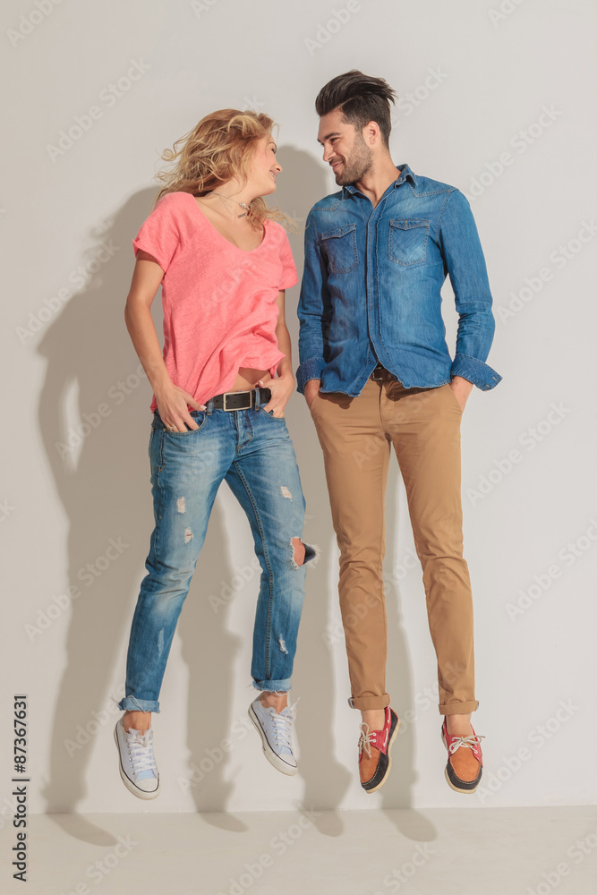 Cute casual couple jumping on studio background Cute casual couple jumping on studio background