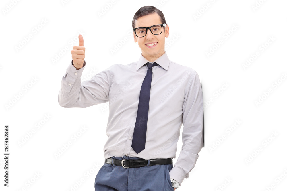 Young elegant man giving a thumb up and looking at the camera Young elegant man giving a thumb up and looking at the camera