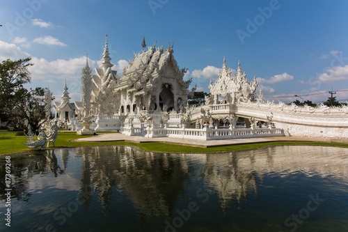 The famous white temple in the Chiang Rai province reflecting in the water