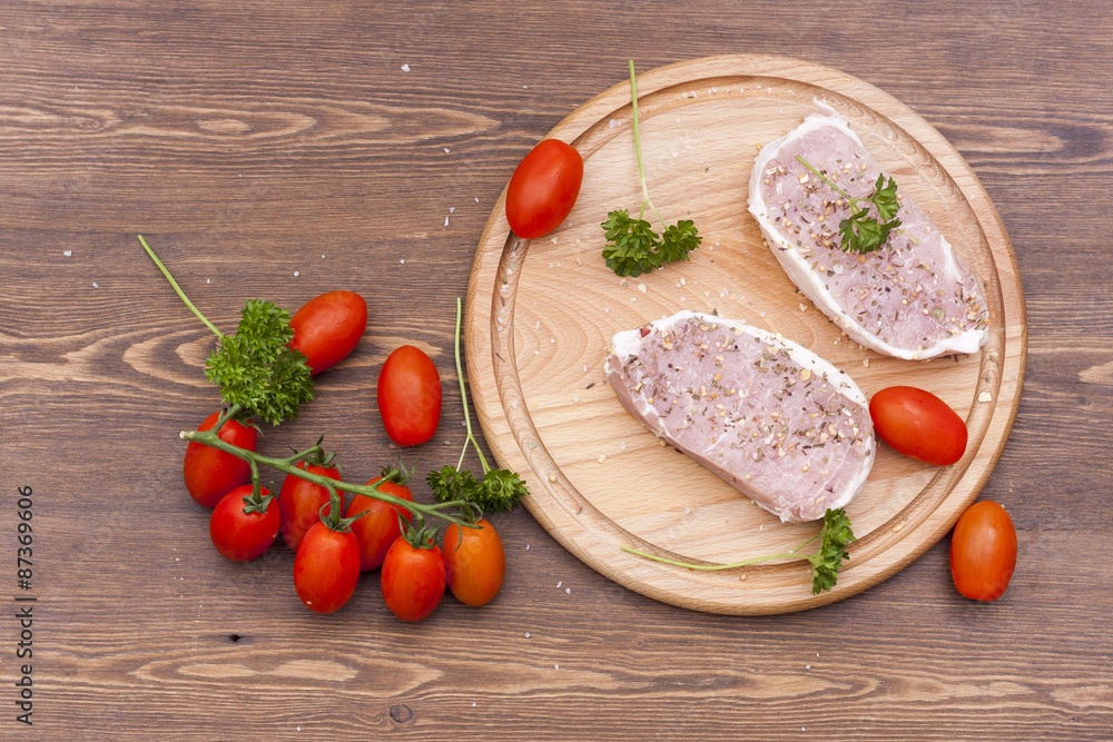 Fresh Raw Steak Meat with spaces, herbs and vegetables on wooden board, selective focus Fresh Raw Steak Meat with spaces, herbs and vegetables on wooden board, selective focus