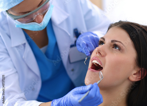 Woman dentist working at her patient  teeth