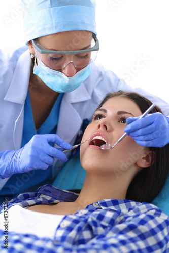 Woman dentist working at her patient teeth