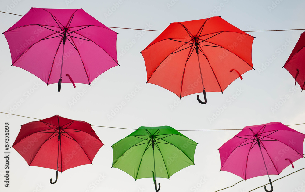 Streets are decorated with colorful umbrellas.
