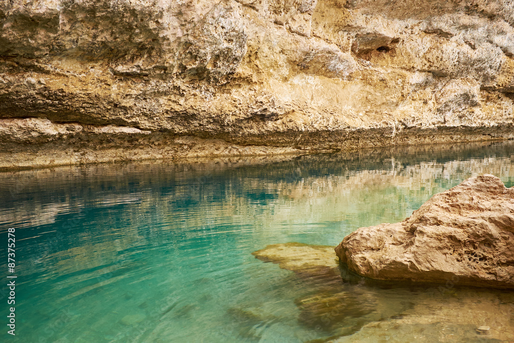Sinkhole with emerald green water at Hawiyat Najm Park, Oman Sinkhole with emerald green water at Hawiyat Najm Park, Oman