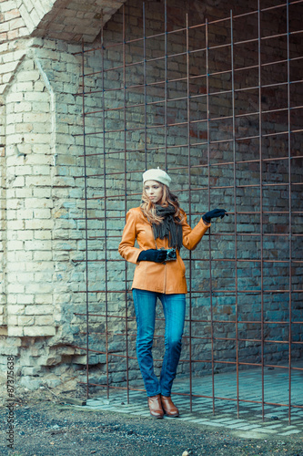 Beautiful girl with an old camera walks through the ancient streets