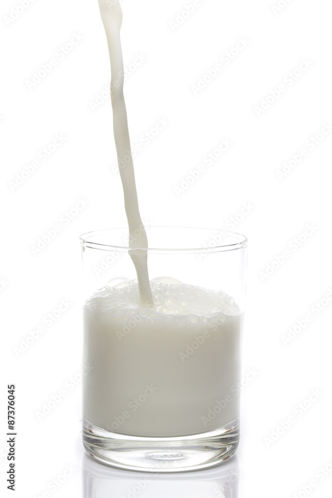 Pouring Milk into Glass on White background Pouring Milk into Glass on White background
