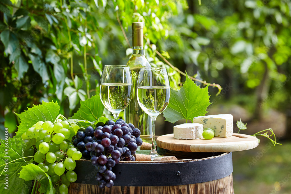 The glass of wine an and old barrel and grape