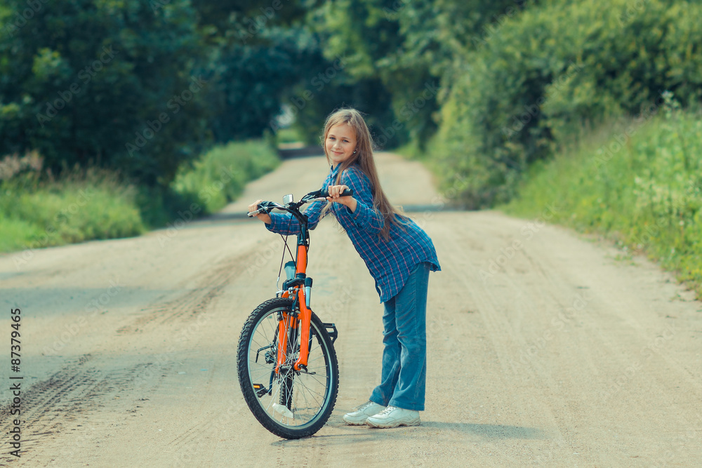 Fototapeta premium Teenager girl with bicycle in countryside outdoors