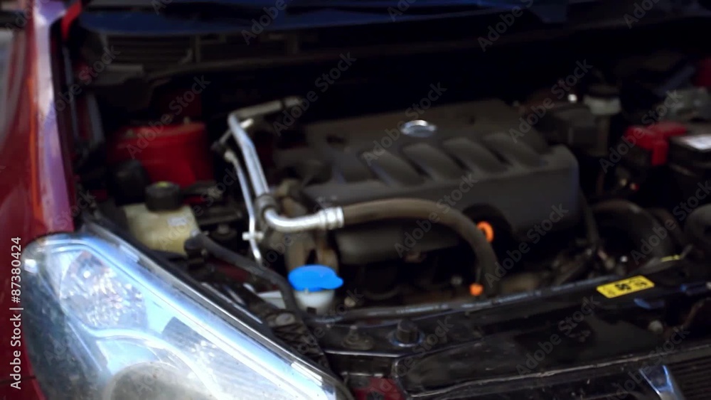 man opens the hood of a car and Filling windshield washer fluid man opens the hood of a car and Filling windshield washer fluid