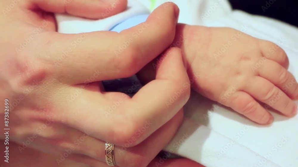 parental hand holds a palm of the baby parental hand holds a palm of the baby