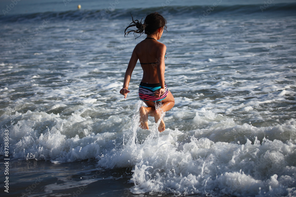 Fototapeta premium Enfant sautant dans les vagues
