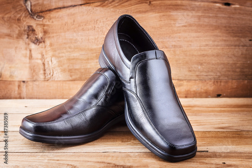 Classic black men's shoes on wood background