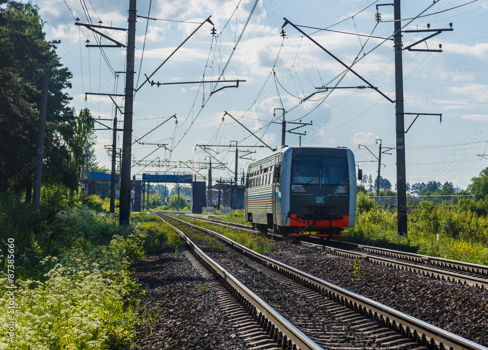 Electric train goes by rail, summer, countryside