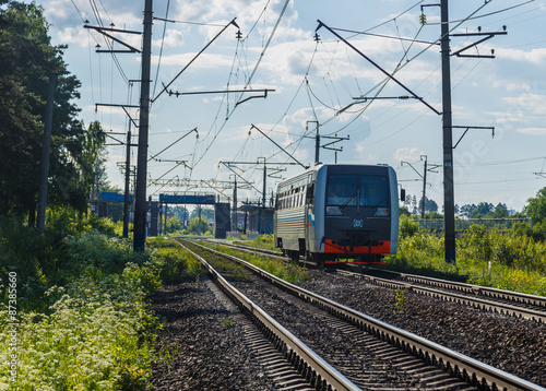 Electric train goes by rail, summer, countryside