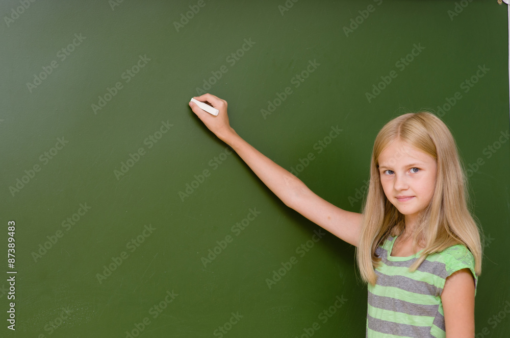 Schoolgirl wants to write something on the blackboard Schoolgirl wants to write something on the blackboard