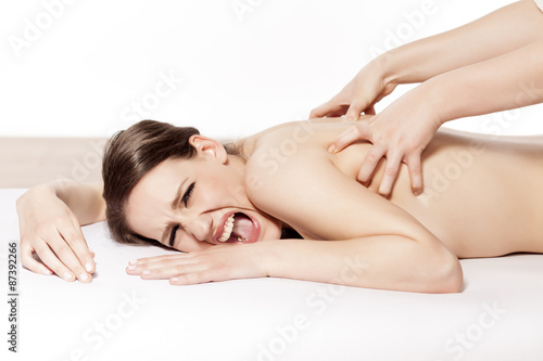 young woman in pain at bad Massage treatment