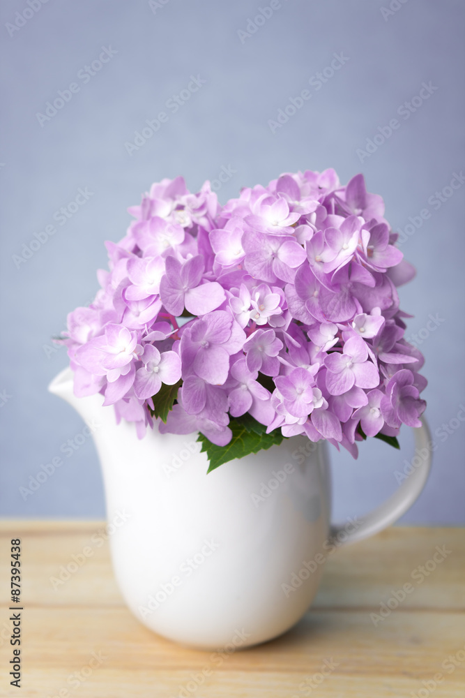 selective focus of sweet purple  hydrangea flowers in white vase