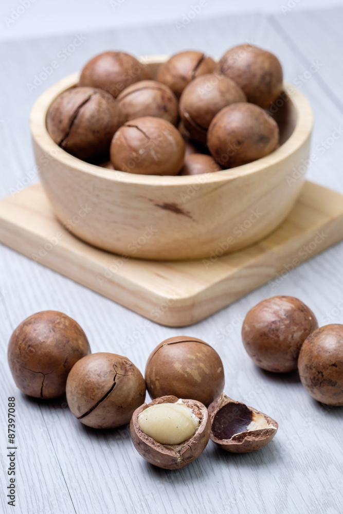Macadamia in wooden bowl on white wooden table Macadamia in wooden bowl on white wooden table