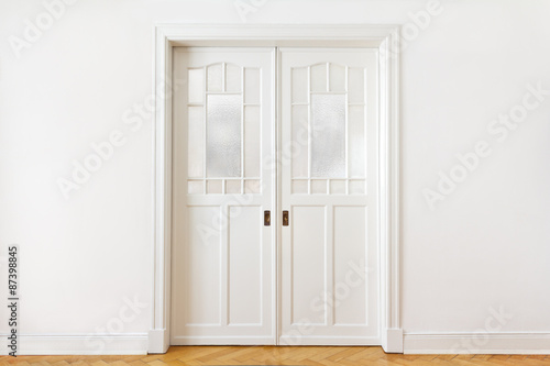 White wall with a double sliding door or pocket doors with textured glass  interior background  copy space.