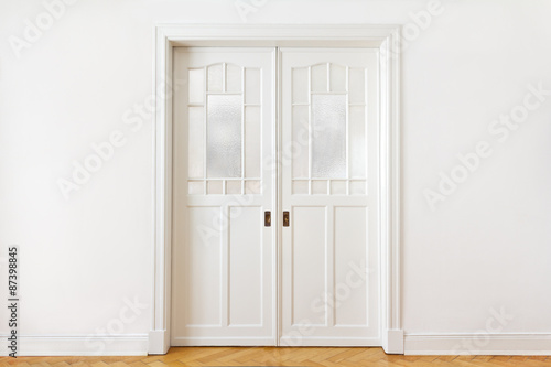 White wall with a double sliding door or pocket doors with textured glass, interior background, copy space.