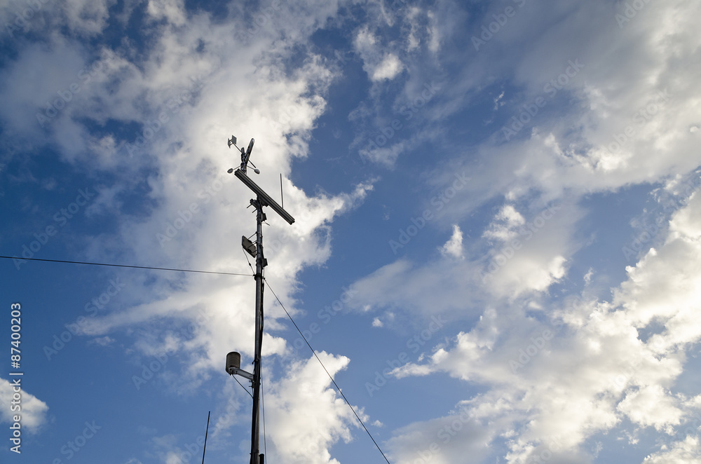 Anemometer and wind vane on blue sky Anemometer and wind vane on blue sky