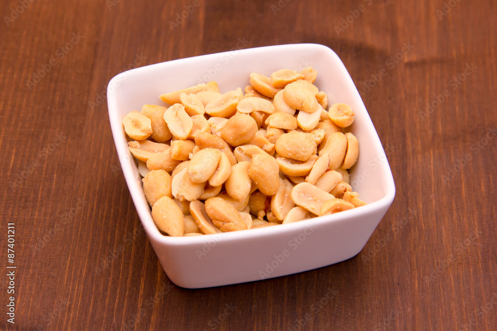 Salted nuts on bowl on wooden table Salted nuts on bowl on wooden table