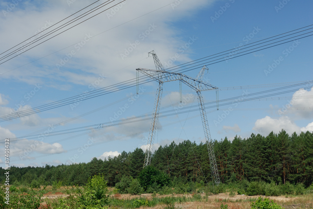 High voltage power line among summer forest.
