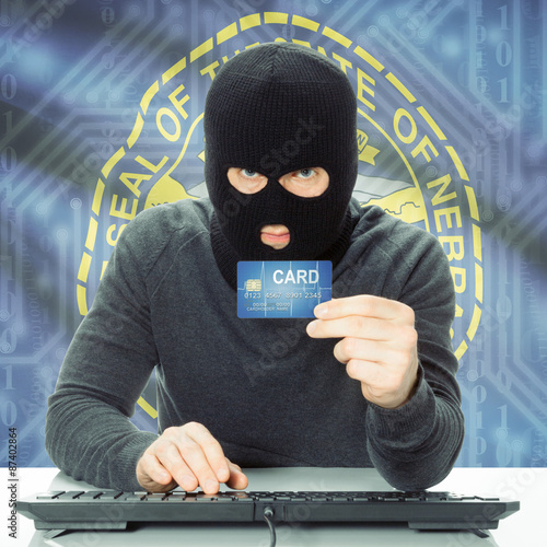 Hacker holding credit card and USA state flag - Nebraska photo