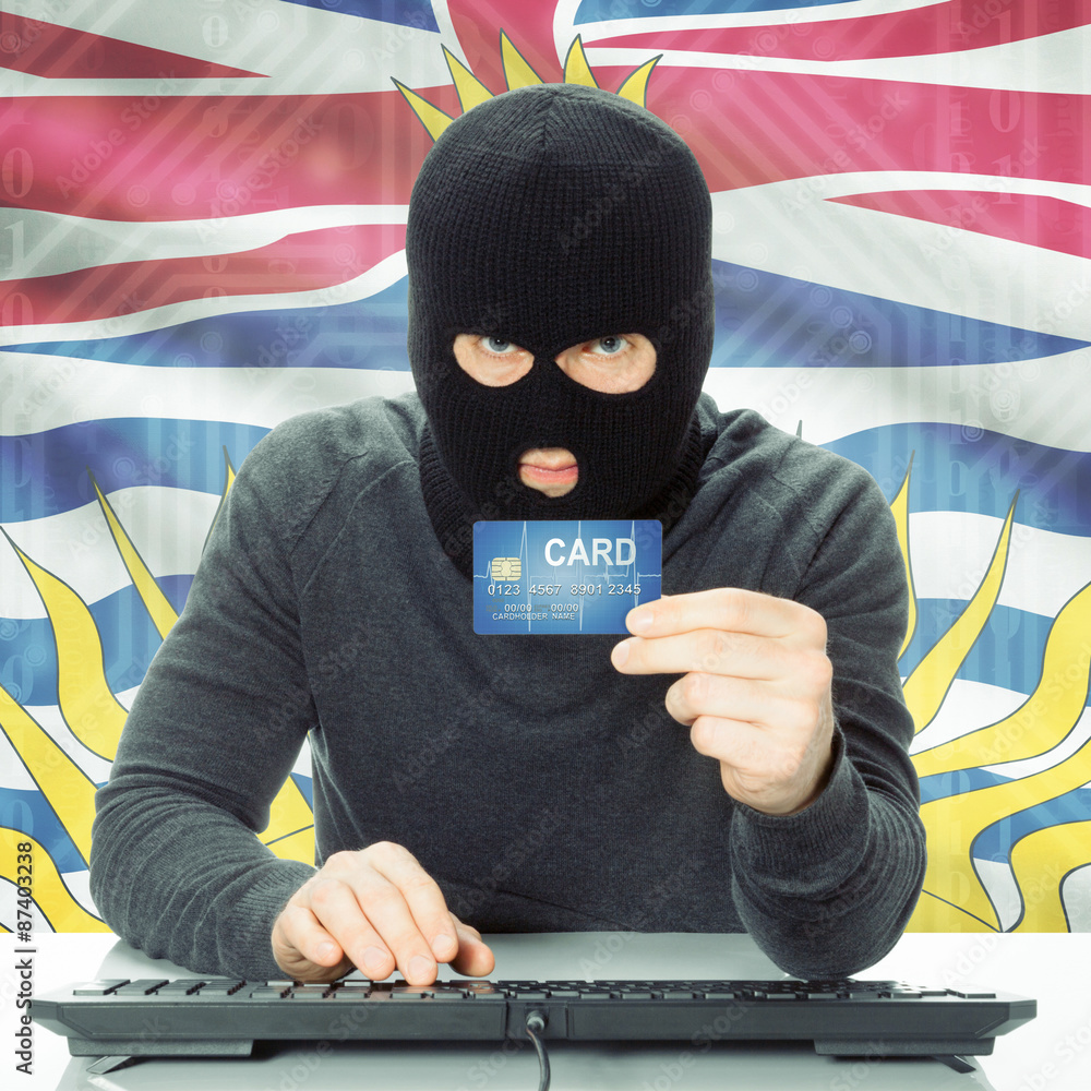 Hacker holding credit card and Canadian province flag - British Columbia Hacker holding credit card and Canadian province flag - British Columbia