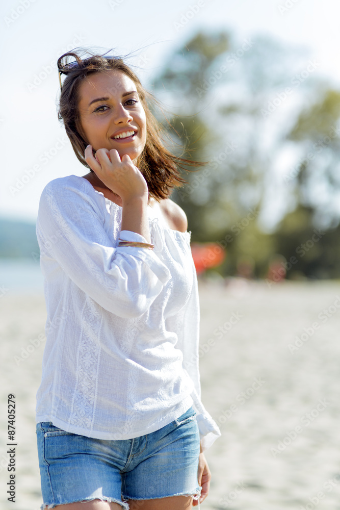 Beautiful young woman posing on a windy summer day