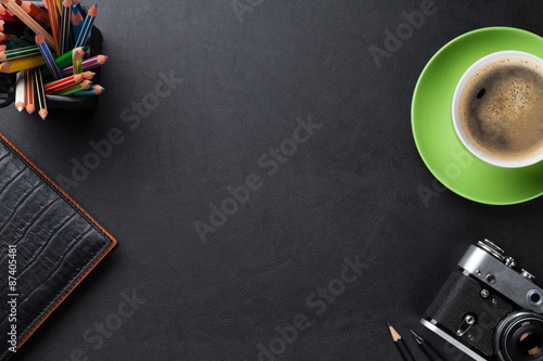 Office desk table with coffee cup, camera and supplies