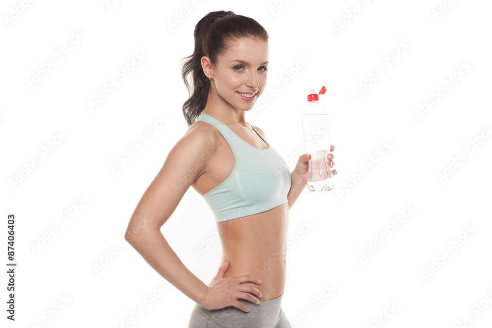 Sporty girl drinking water from a bottle after a workout, fitness training, isolated on white background Sporty girl drinking water from a bottle after a workout, fitness training, isolated on white background