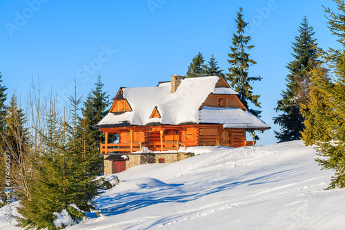 Mountain hut built of wood logs in Gorce Mountains in winter season, Poland #87406639