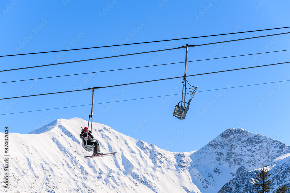 Unidentified skiers on lift in beautiful winter scenery of Tatra Mountains, Slovakia Unidentified skiers on lift in beautiful winter scenery of Tatra Mountains, Slovakia