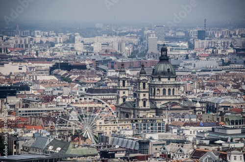 View over cupola of basilica of saint istvan and over ferris wheel situated in historical center of budapest. photo