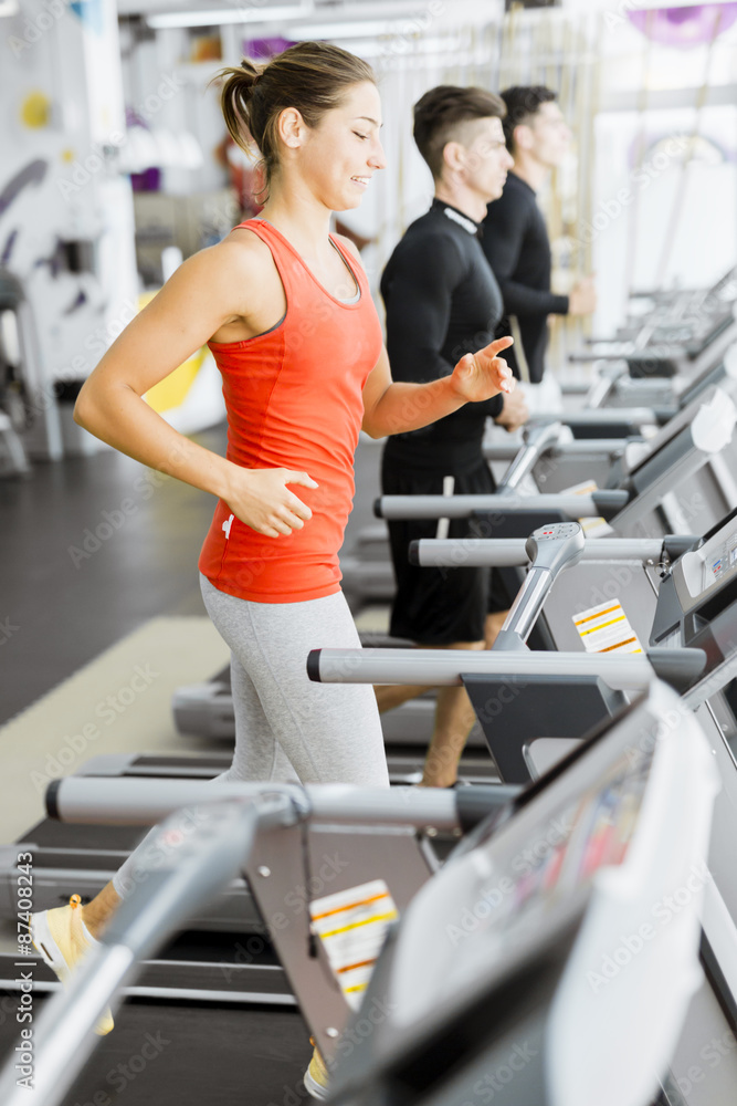 Group of young people using treadmills in a gym Group of young people using treadmills in a gym