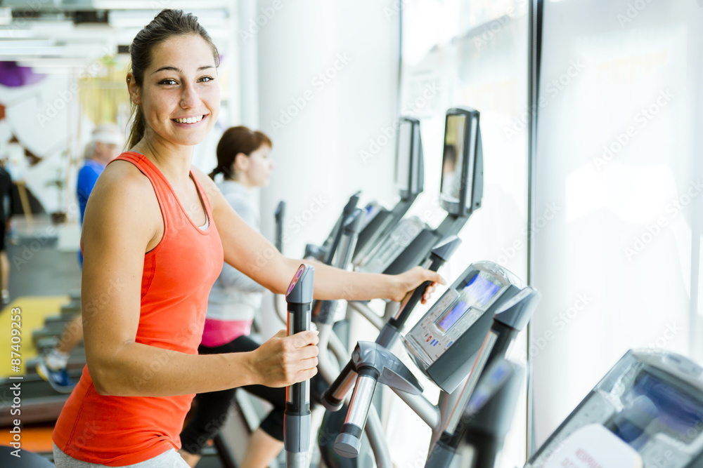 Young fit woman using an elliptic trainer Young fit woman using an elliptic trainer