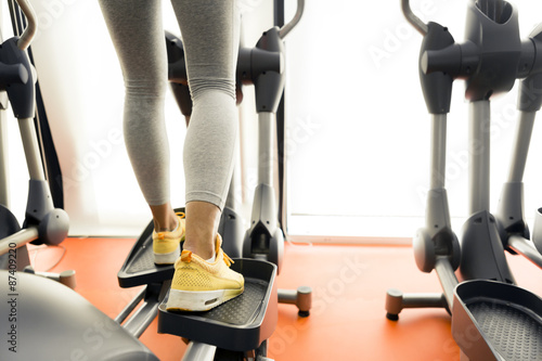 Closeup of a woman using a stepper and training in a gym photo