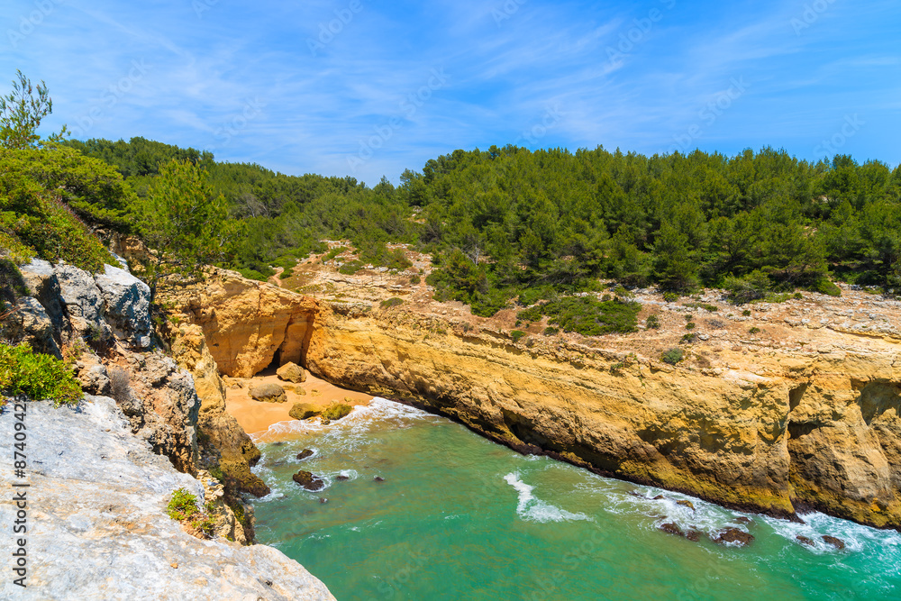 Secluded beach in bay with rocky cliffs on coast of Algarve region, Portugal