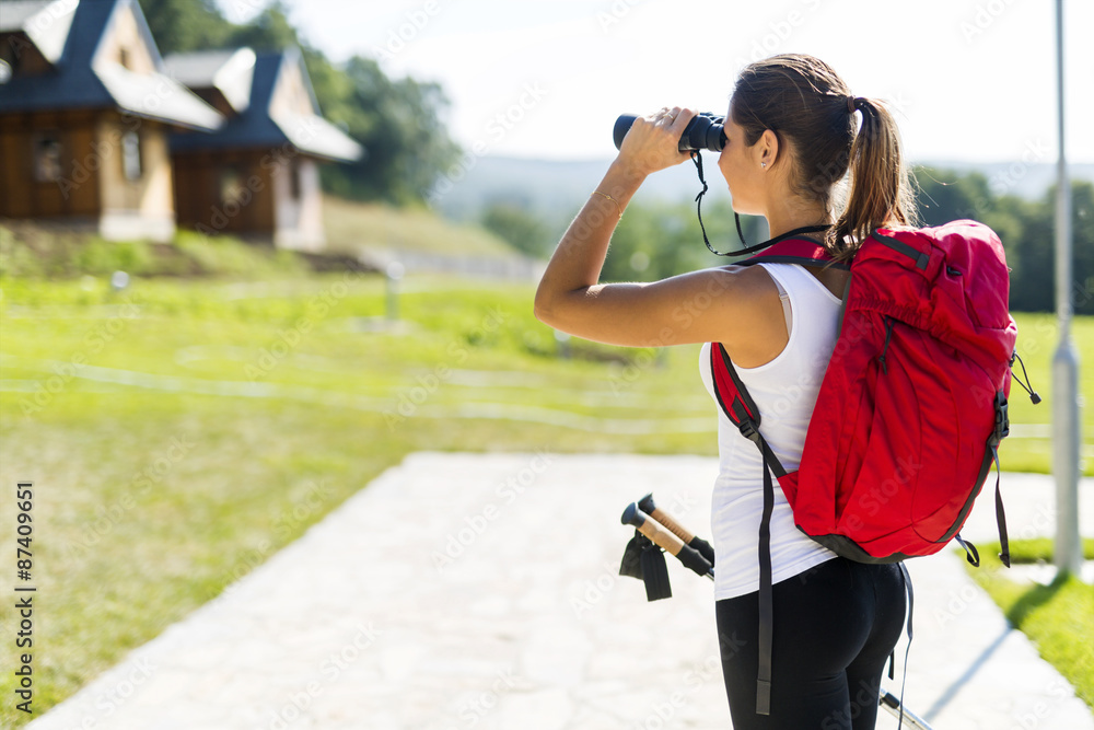 Beautiful tourist hiking and using binoculars