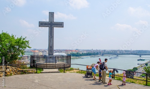 Photography family is admiring danube river from place with cross on gellert hegy hill